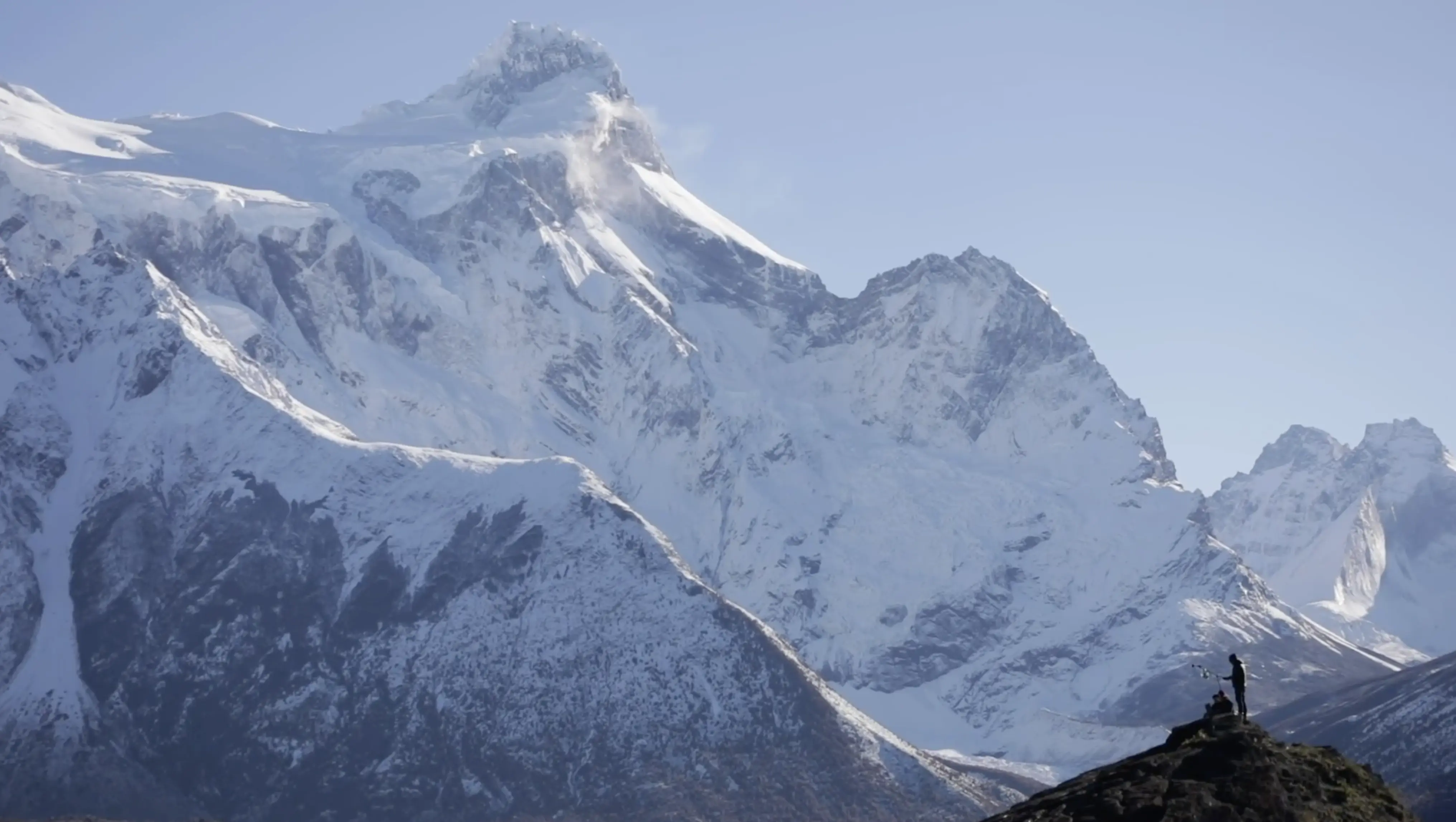 A lone figure on a ridge before the Patagonian peaks